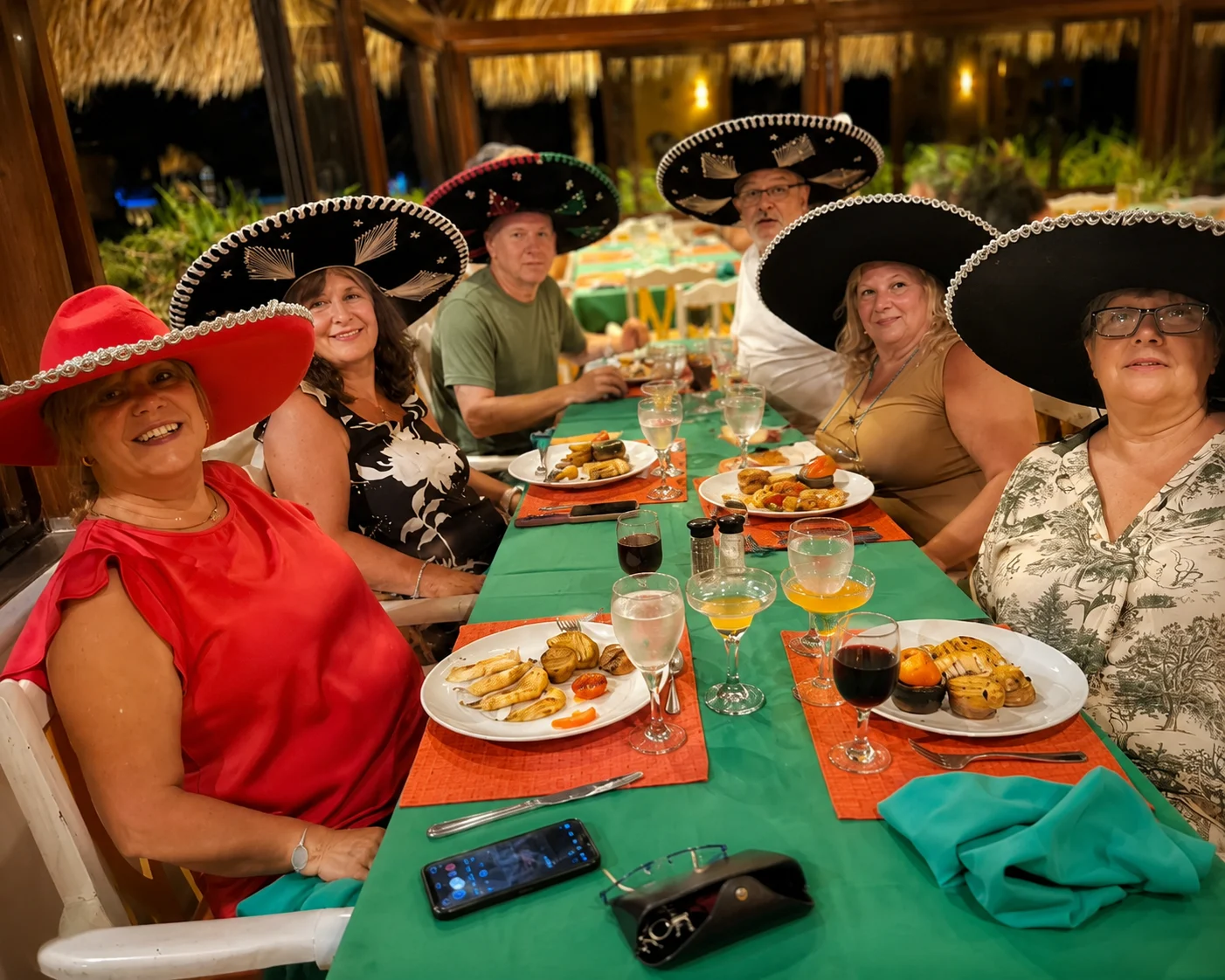 Viajeras con sombreros comparten una cena durante su viaje
